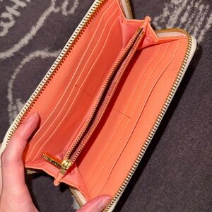 Tory Burch Robinson Zip Continental Wallet in a white and orange color scheme